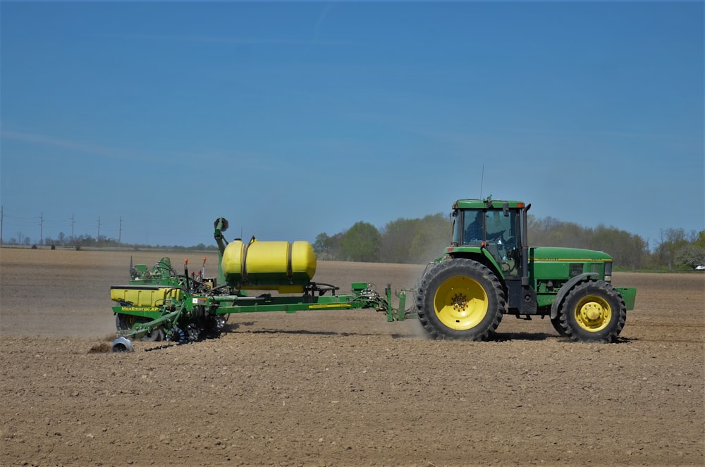 green tractor on brown sand under blue sky during daytime