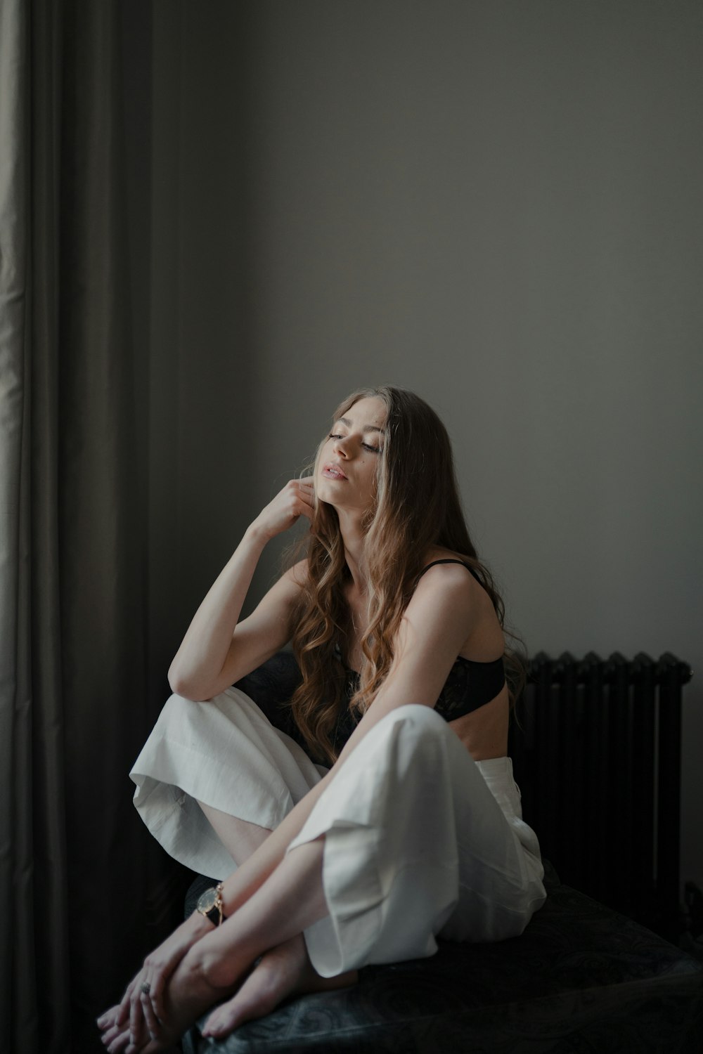 woman in black brassiere covering her face with white blanket