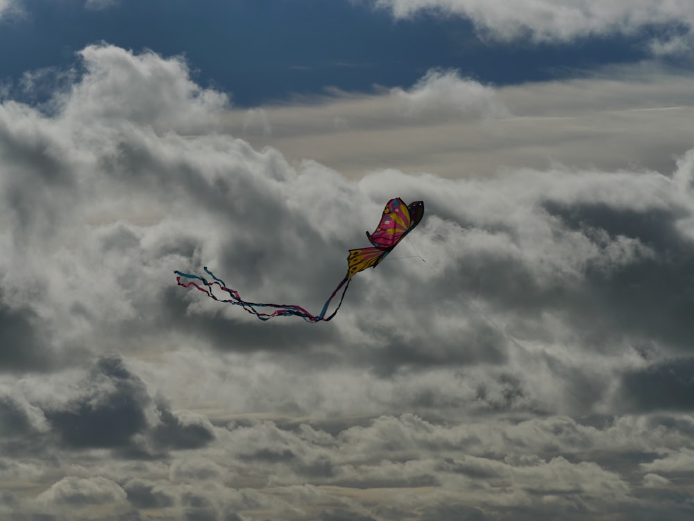 red and black kite flying under white clouds during daytime