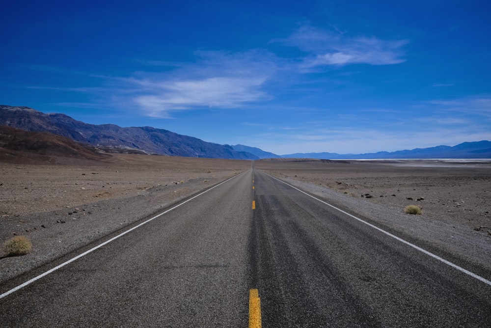 estrada de asfalto cinza sob o céu azul durante o dia