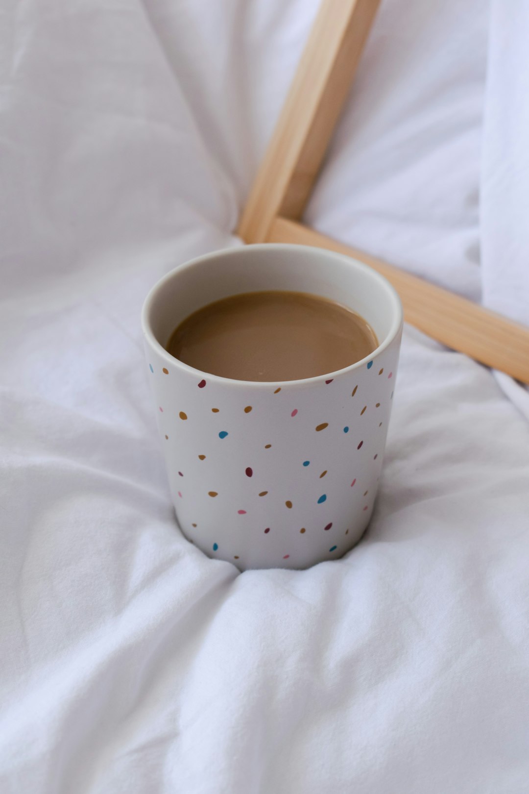 white and blue polka dot ceramic mug on white textile