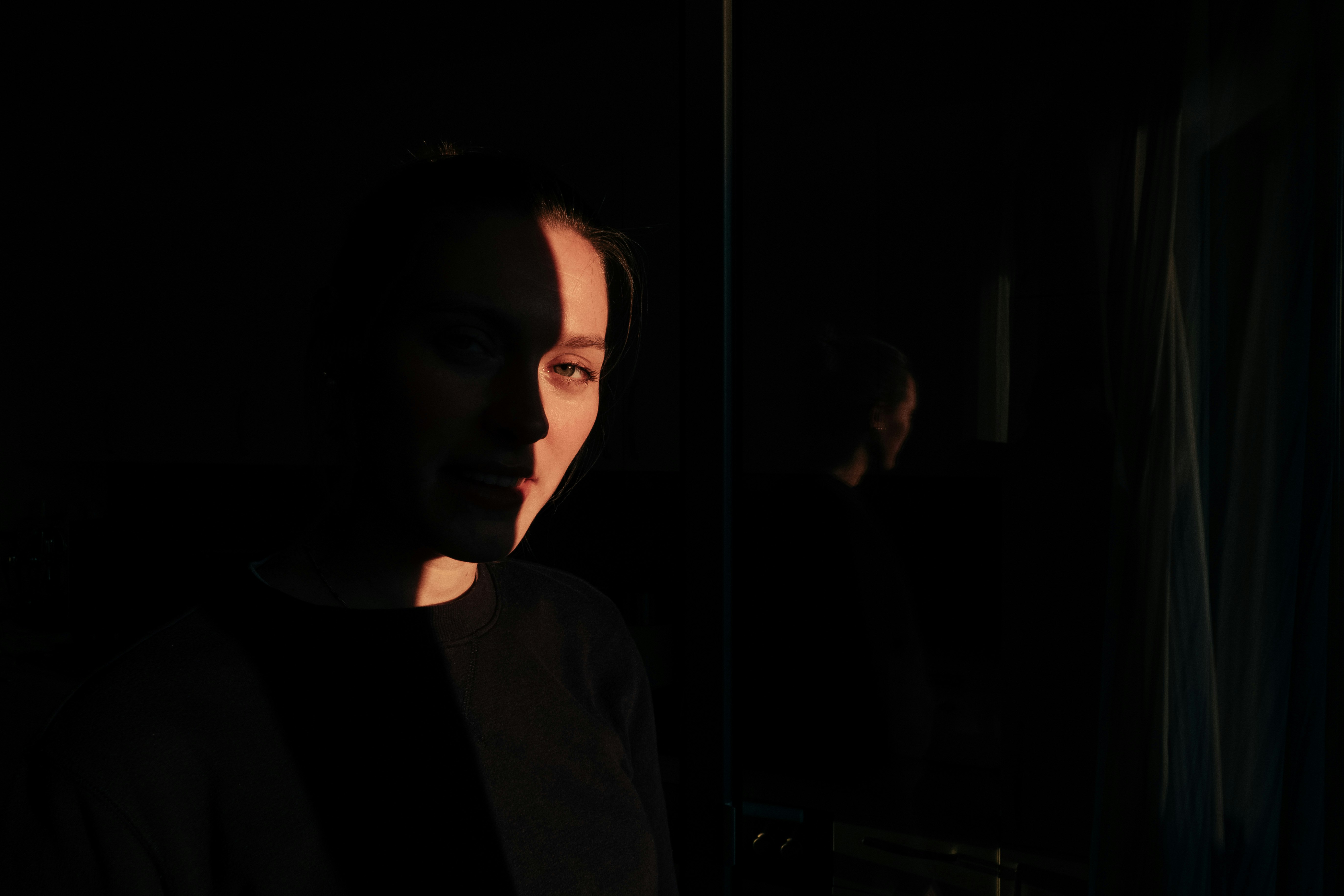 woman in black shirt standing near glass window
