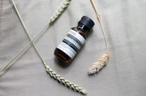 A sleek amber tincture bottle resting beside fresh herbs and a gold-accented dropper.