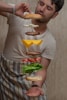 man in white crew neck t-shirt holding burger