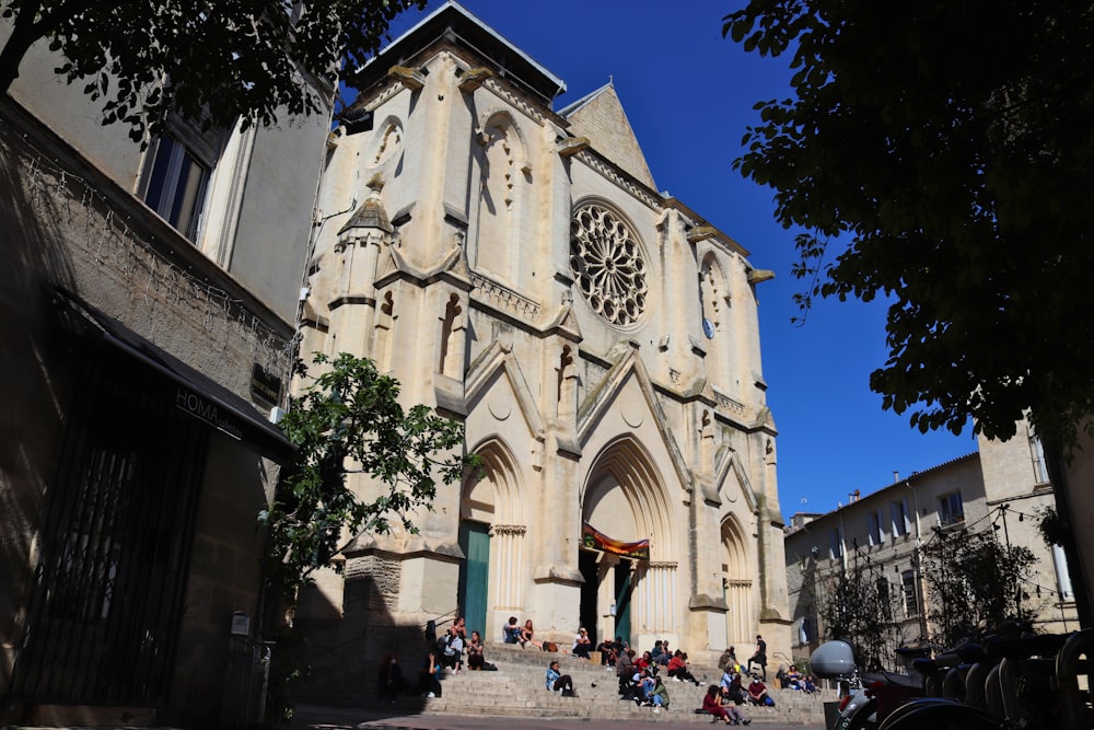 Menschen, die tagsüber in der Nähe der weißen Betonkirche spazieren gehen