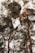 A creative double exposure photograph of two people facing each other, with their profiles merging seamlessly with a forest scene of tall, leafy trees. The trees and the human figures are intertwined, creating a surreal and artistic effect.