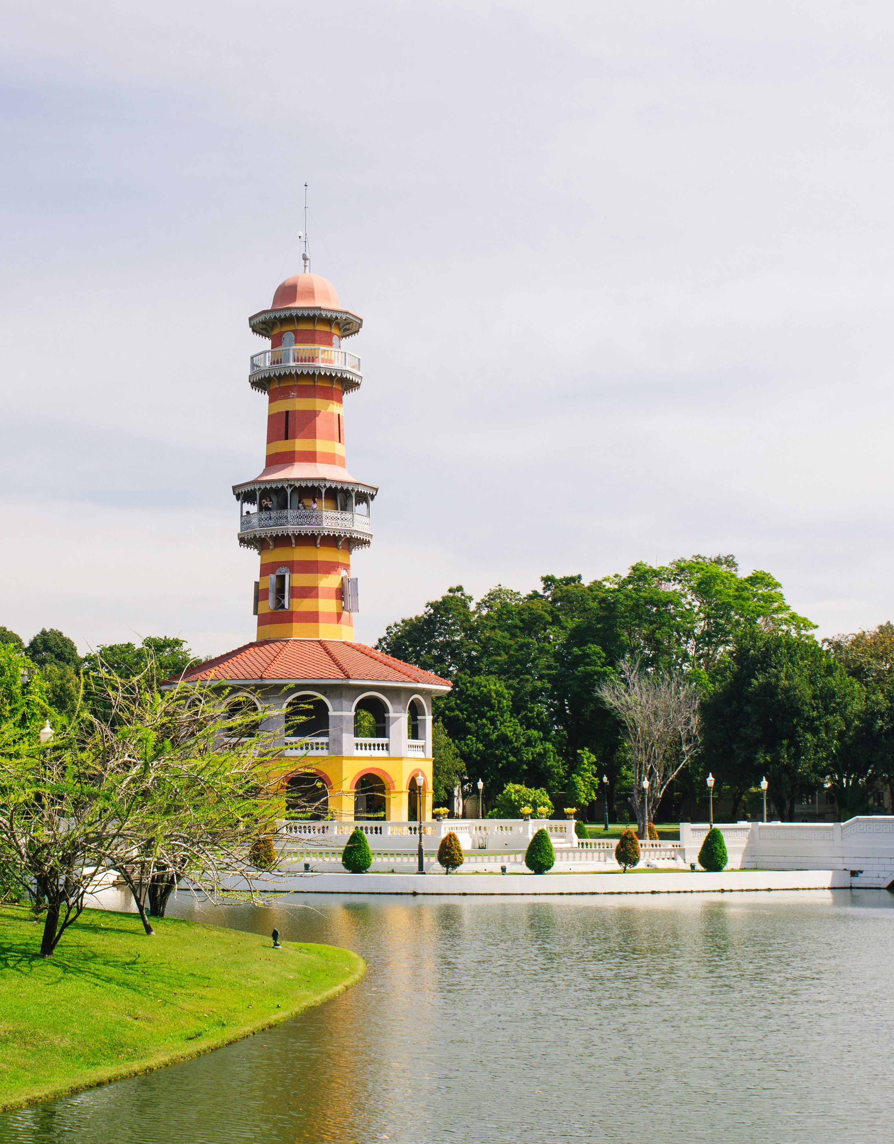 brown and white concrete building near green trees and body of water during daytime