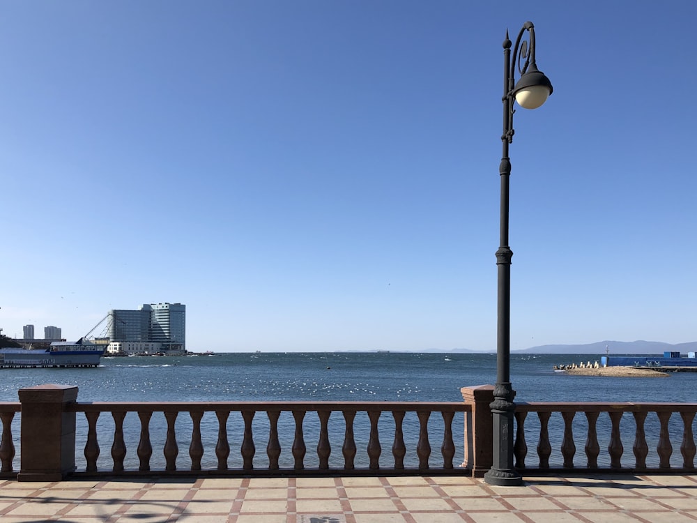 black lamp post near sea during daytime