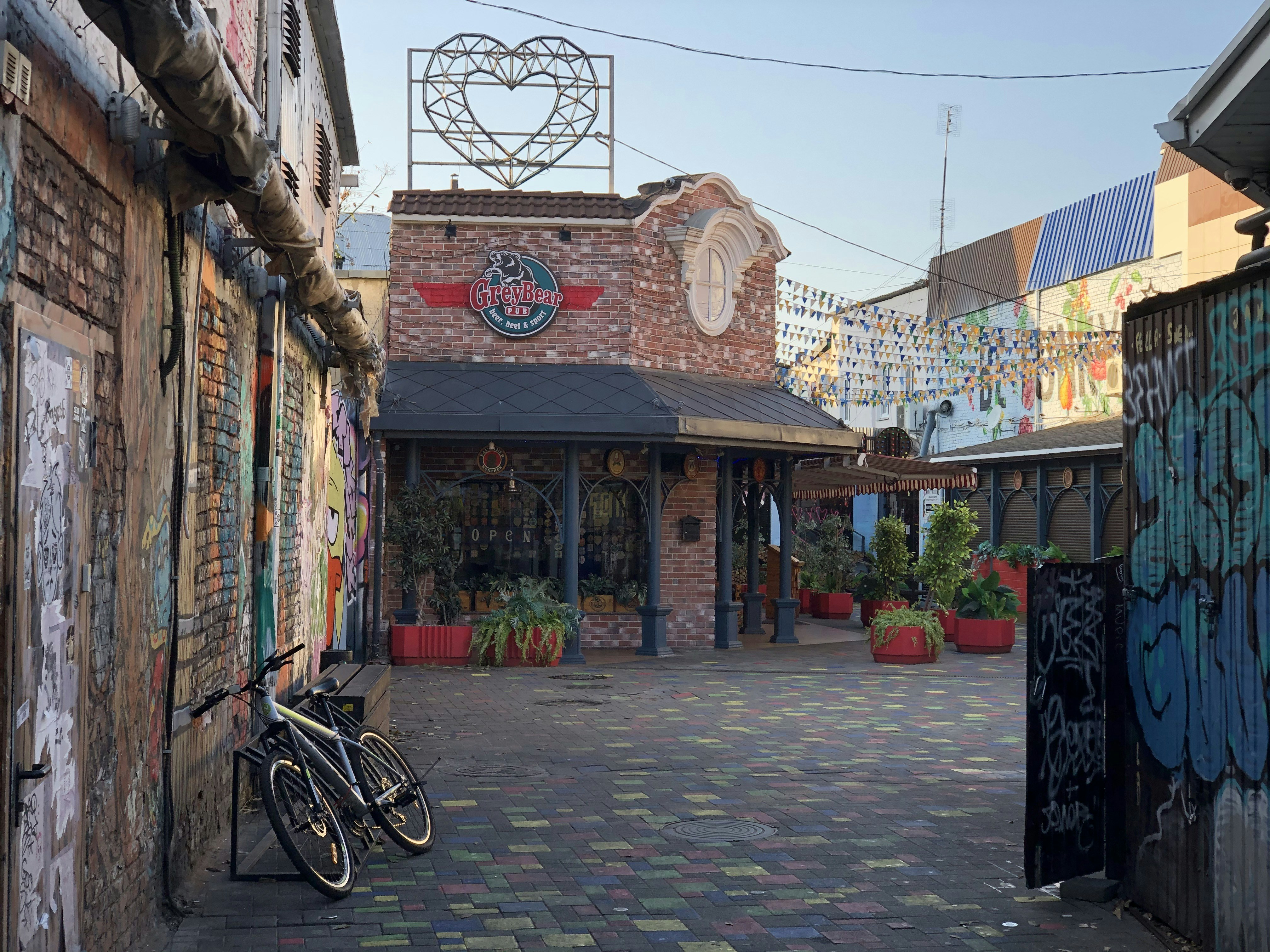 black bicycle parked beside brown concrete building during daytime