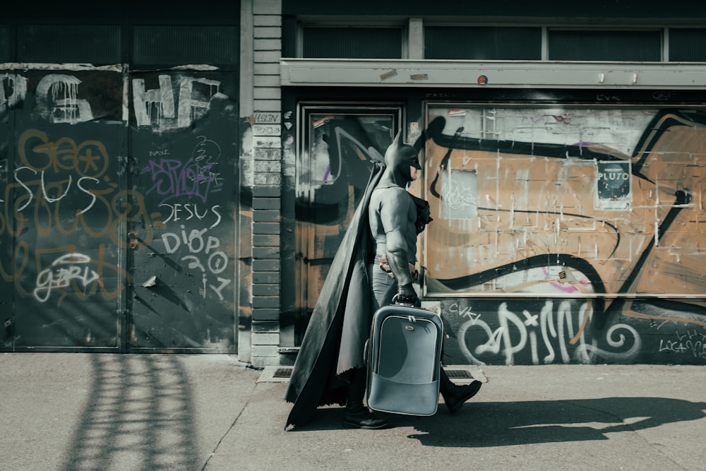 man in gray robe walking on sidewalk during daytime