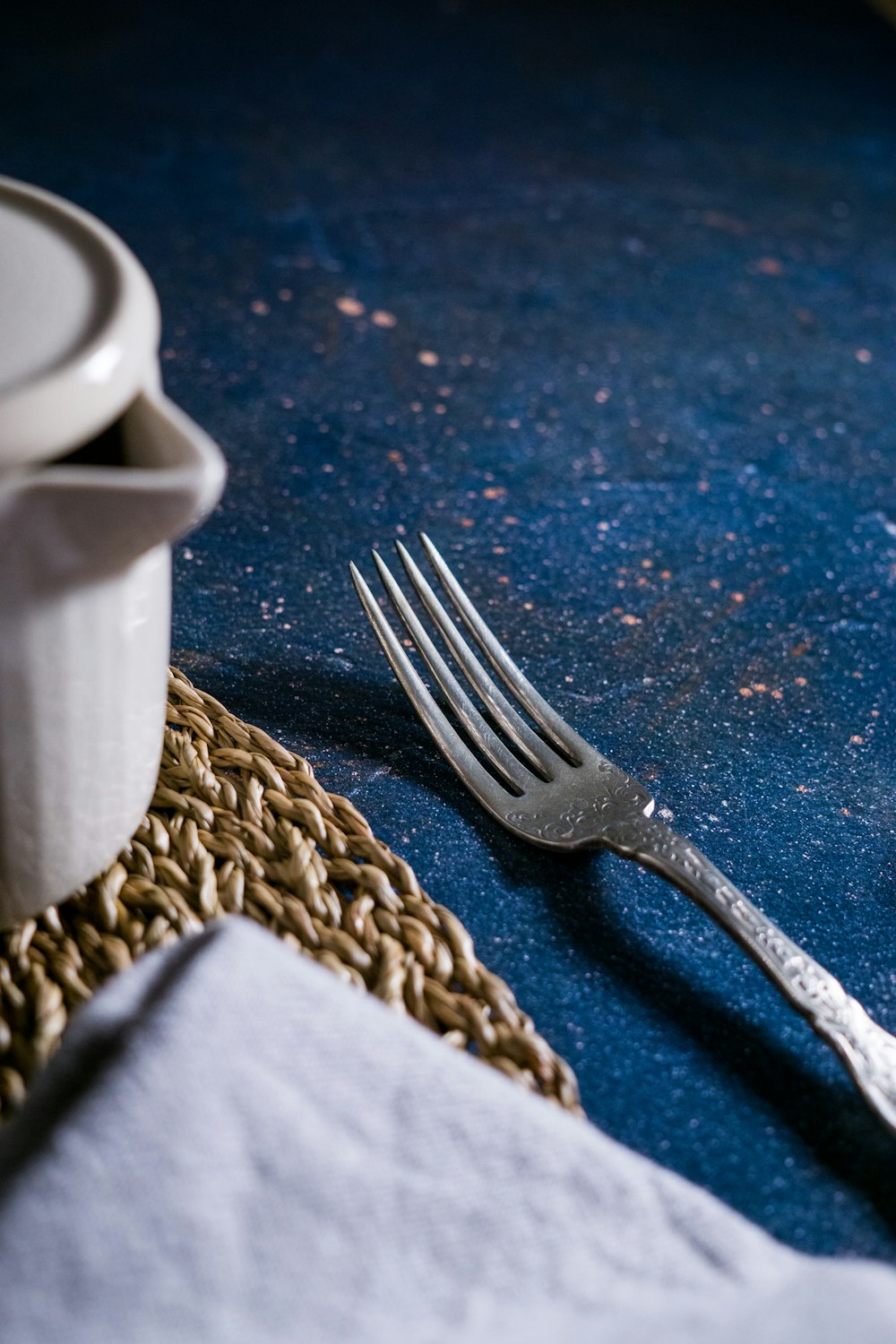 silver fork beside white ceramic mug