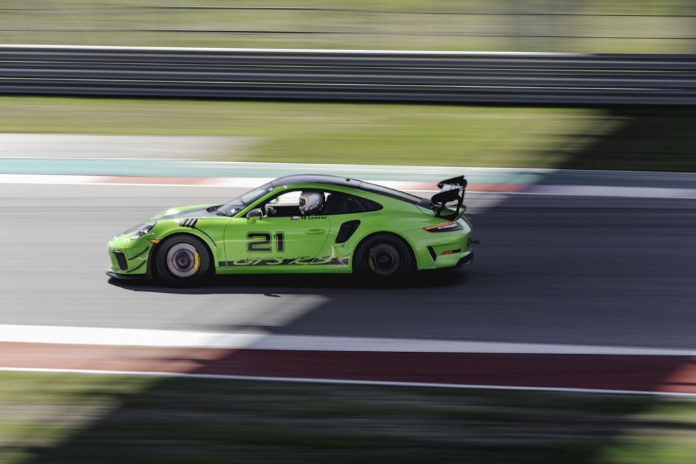 green and black porsche 911 on road