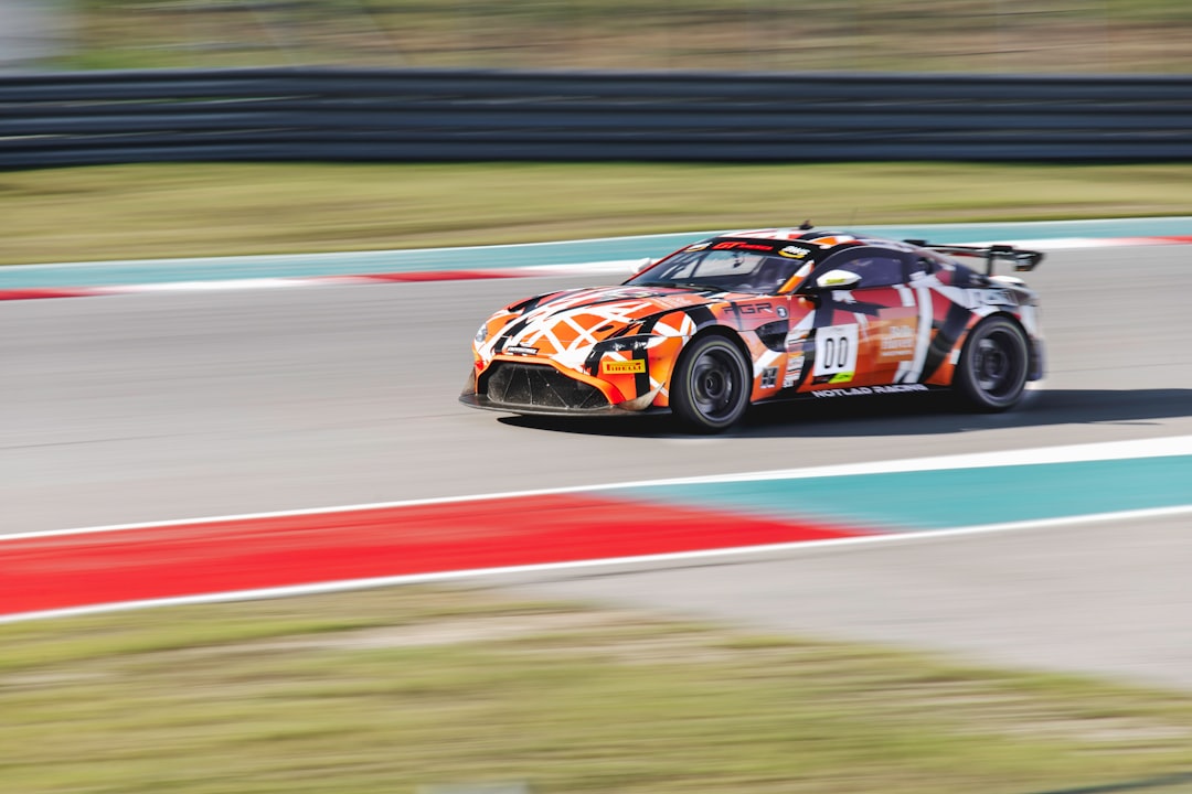 red and black sports car on track field during daytime