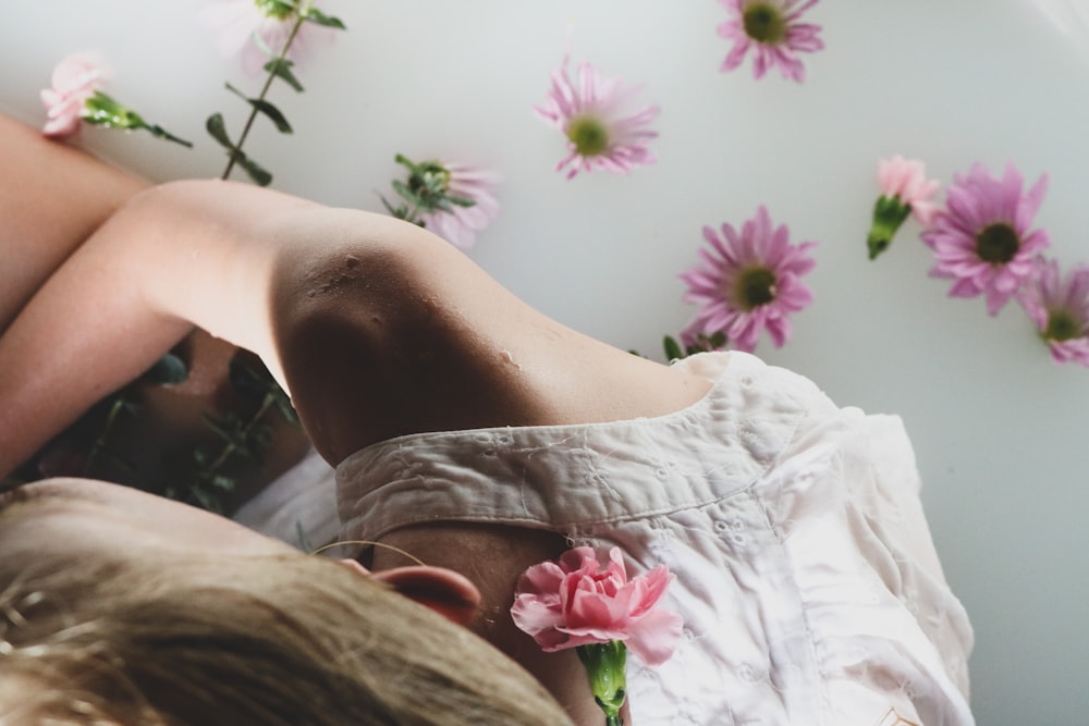 person in white and pink floral shorts lying on bed