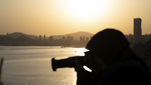A photographer capturing a sunset over a city skyline.