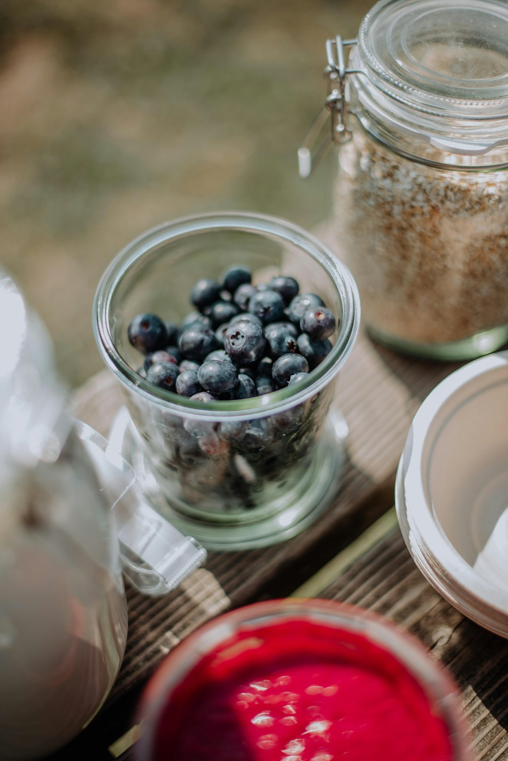 red and black berries in clear glass jar