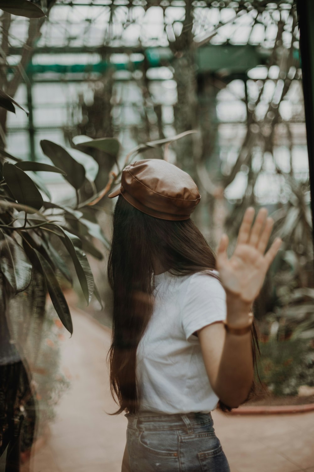 woman in white t-shirt covering face with brown leaf