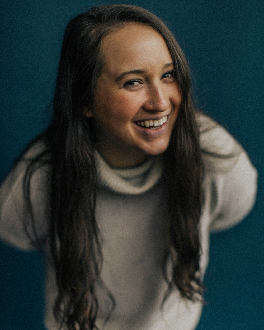 smiling woman in white turtleneck sweater