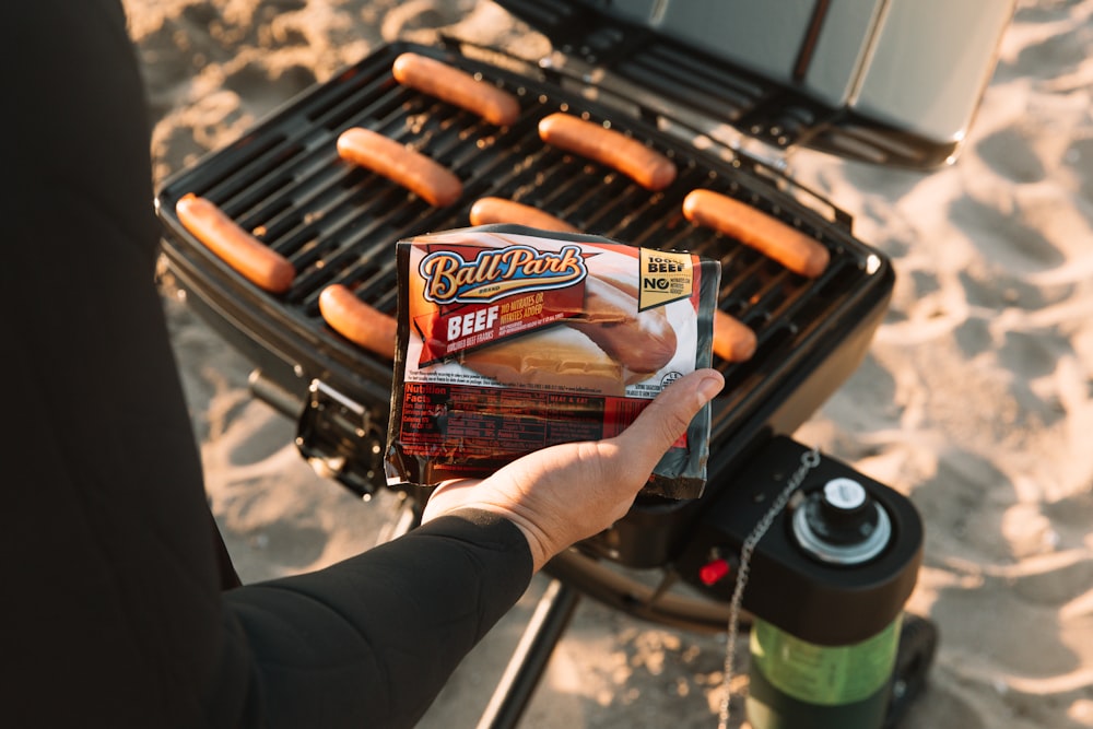 person holding a brown and black plastic pack