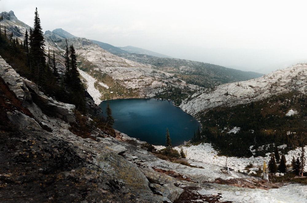 lake in the middle of mountains during daytime