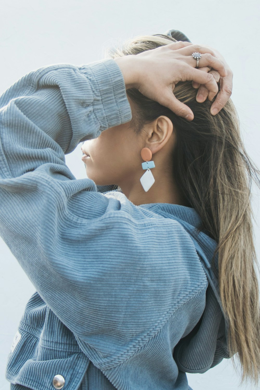 Femme en pull bleu avec un ruban blanc sur ses cheveux