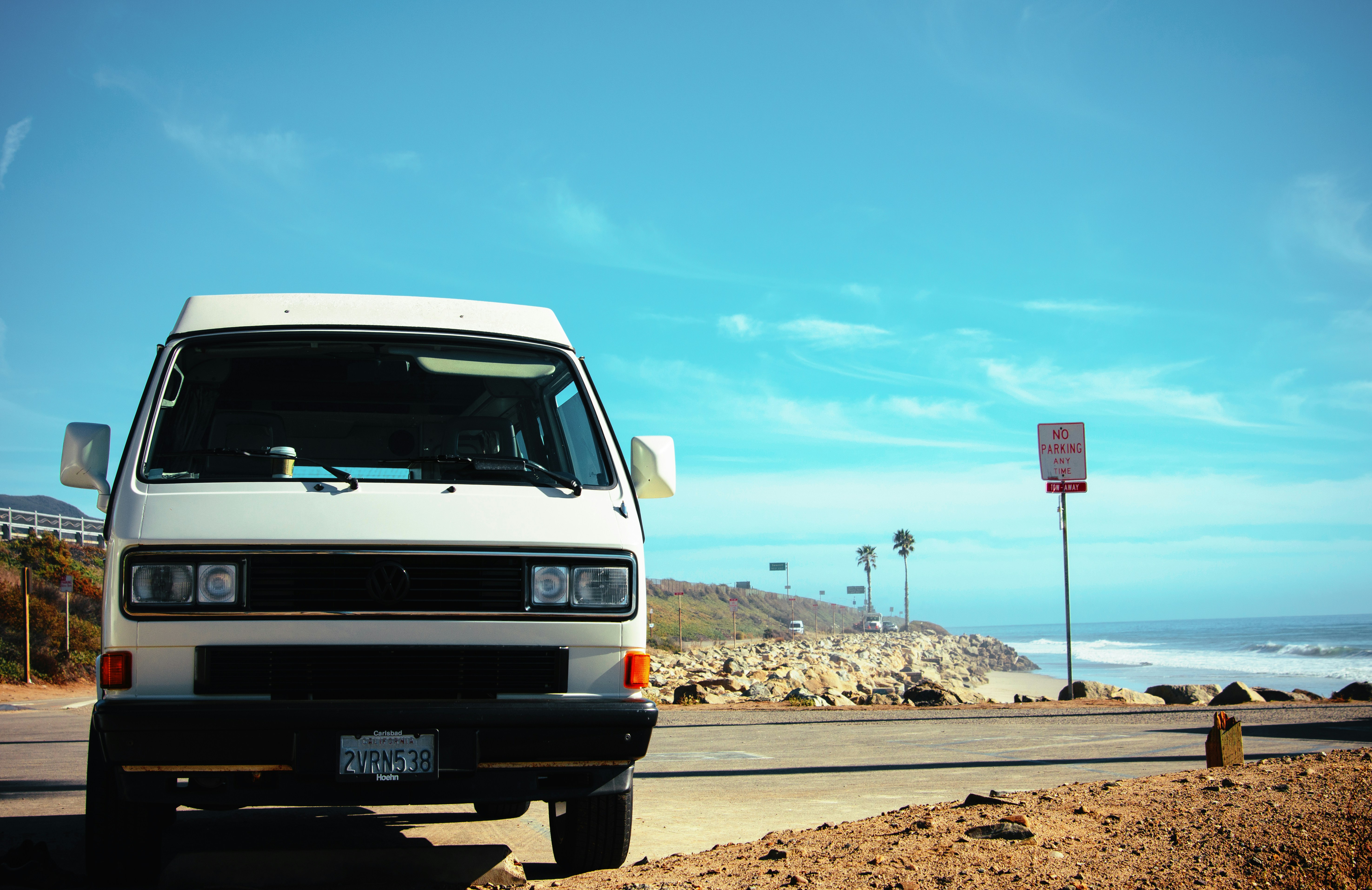 white ford van on brown sand under blue sky during daytime