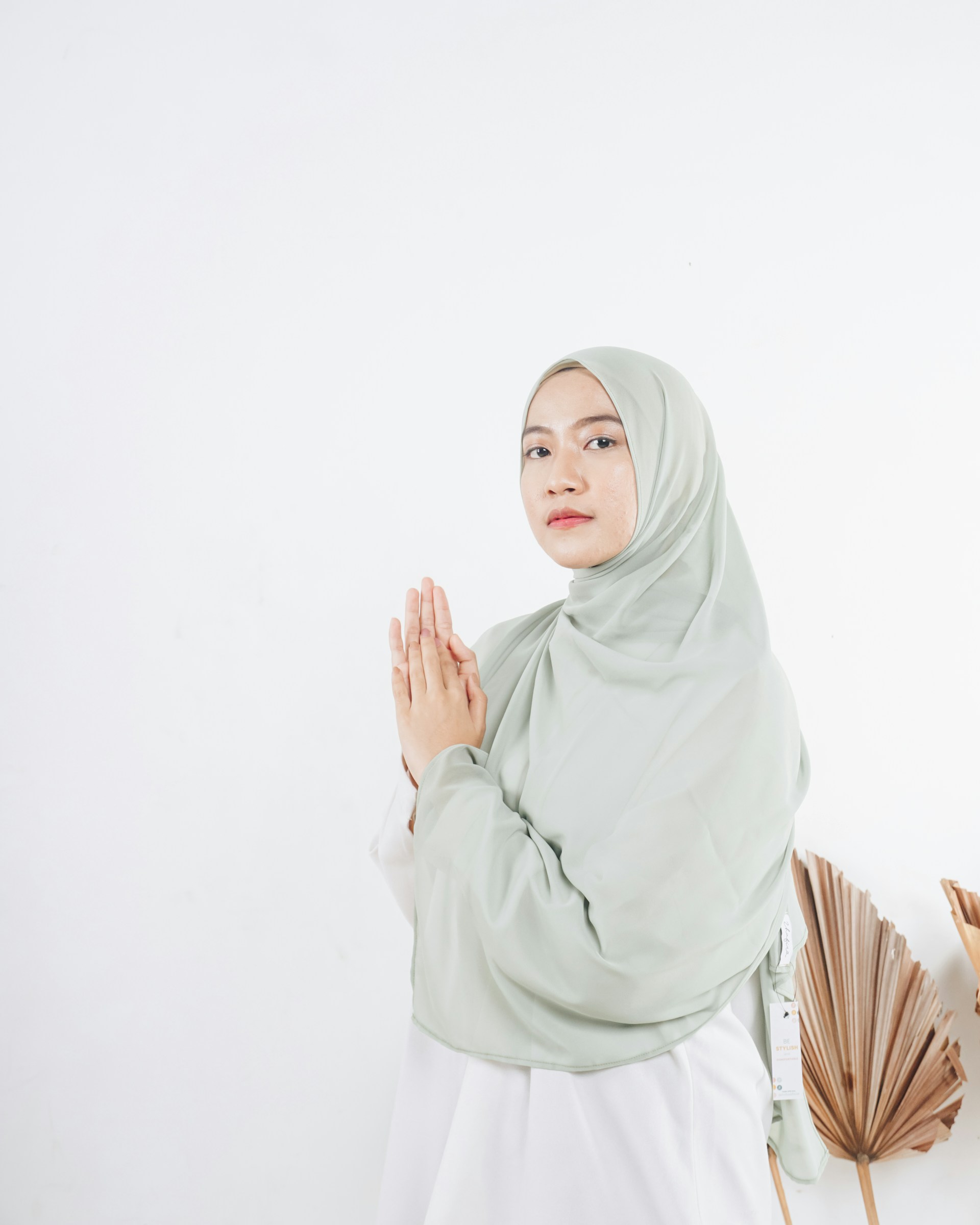 woman in white hijab standing near white wall