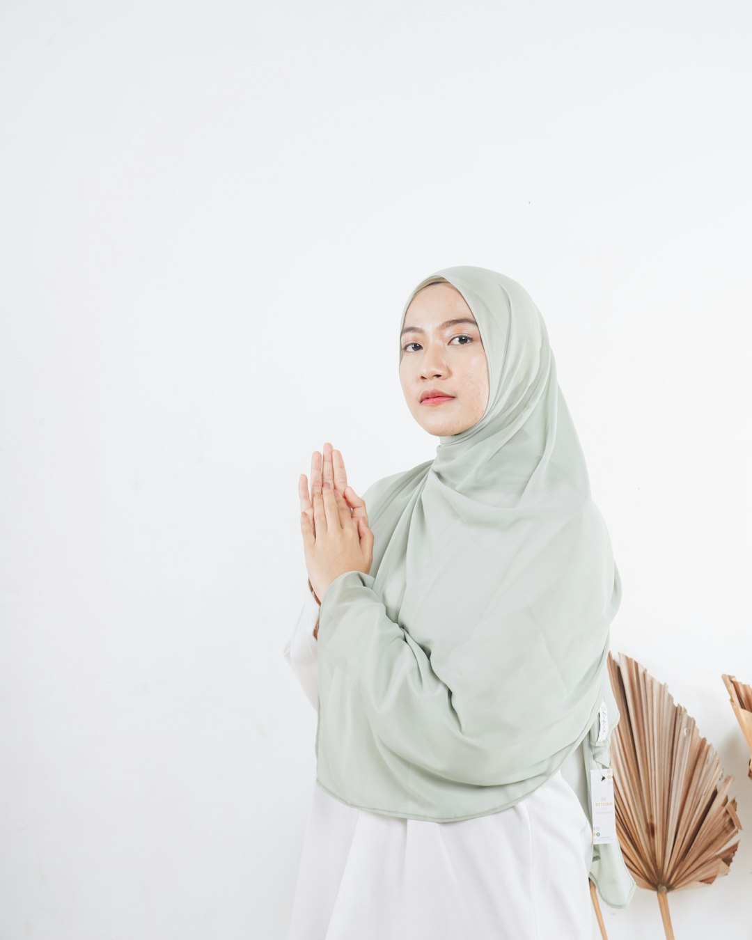 woman in white hijab standing near white wall