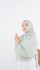 woman in white hijab standing near white wall