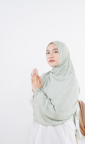 woman in white hijab standing near white wall