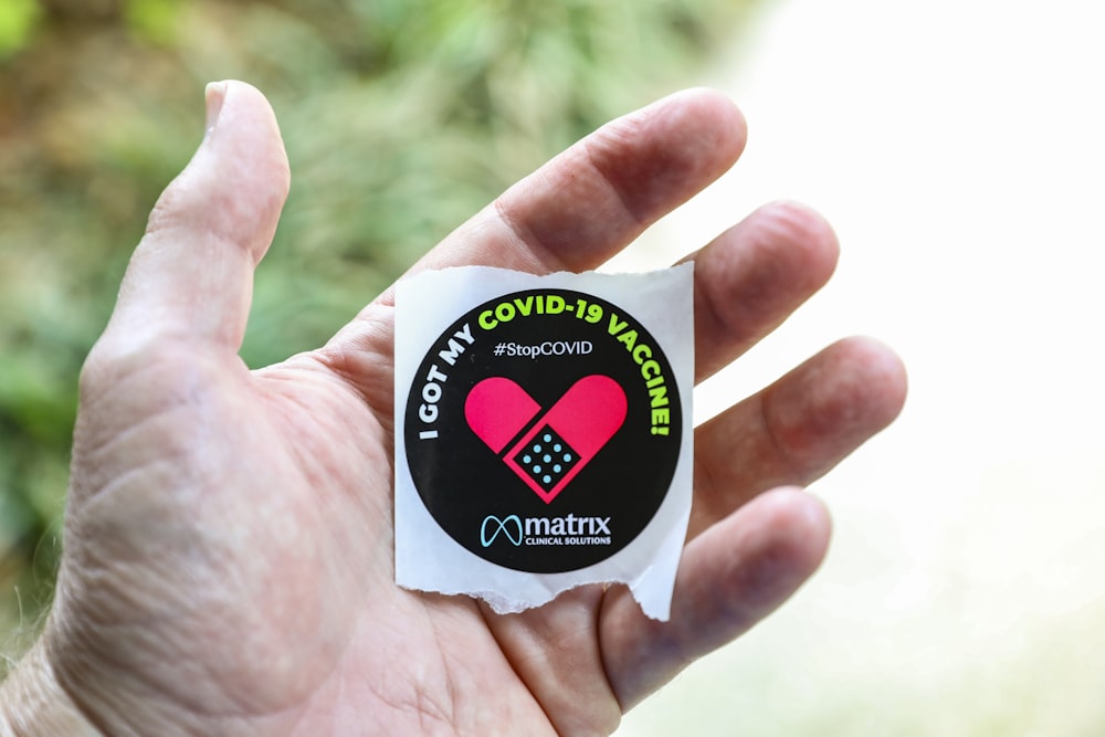 a person holding a sticker in their hand
