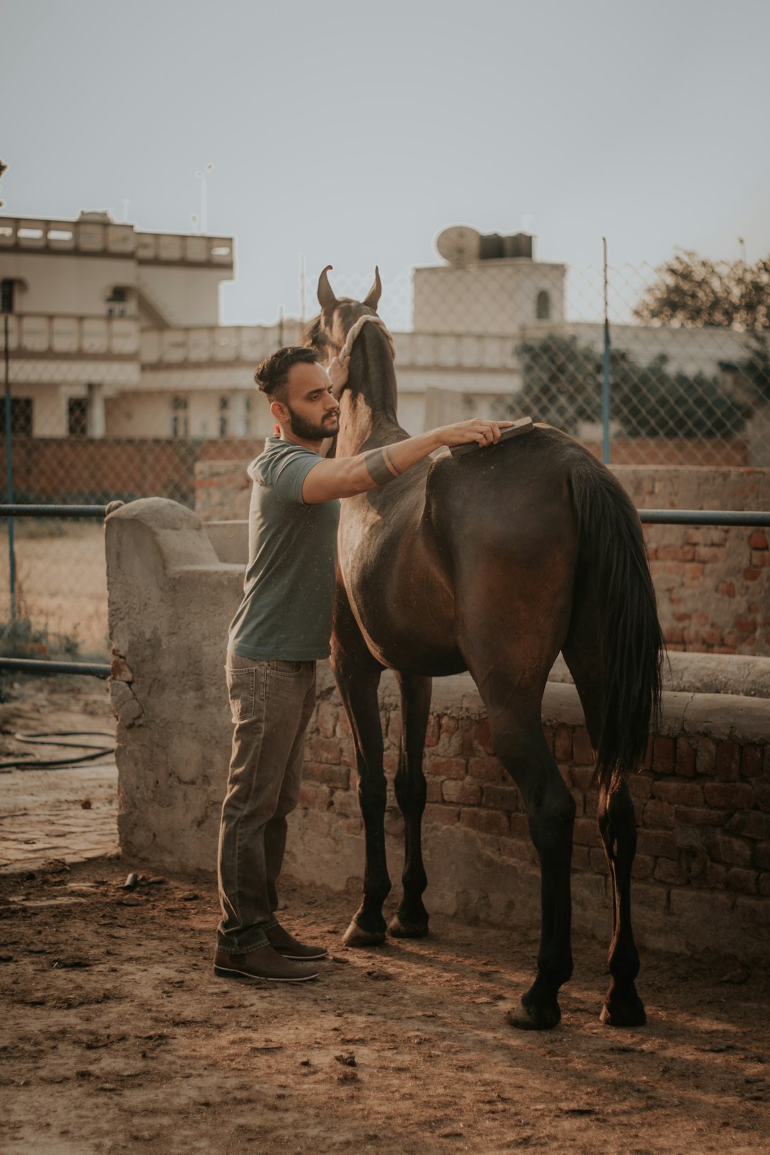 woman in gray shirt and gray pants riding brown horse during daytime