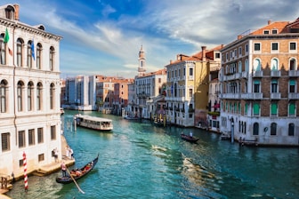 boat on water between buildings during daytime