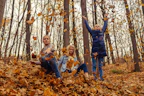 Little girl bundled in a cozy jacket playing in autumn leaves