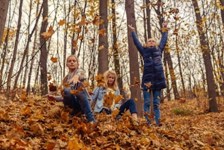 Kids raking leaves together on a bright autumn day.
