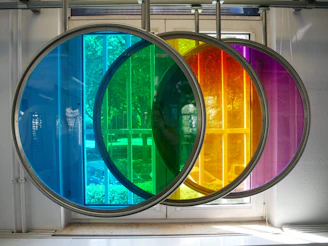 A vibrant, backlit glass panel installed in a modern interior, casting colorful reflections.