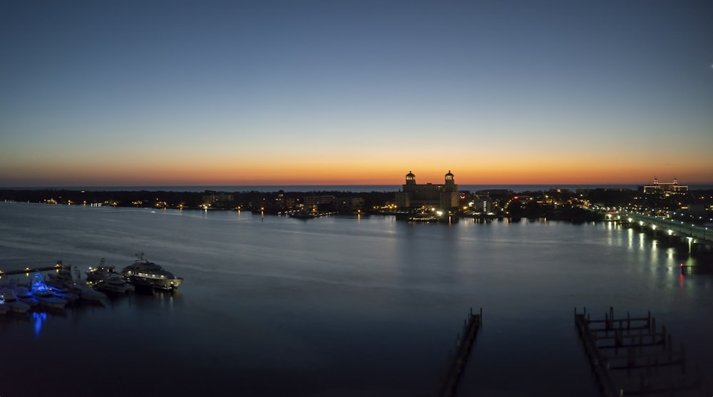 body of water near city buildings during night time