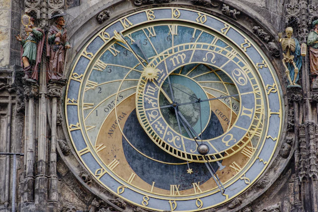 Close view of Prague's Astronomical Clock face with its zodiac ring and the flanking carved figures on the Old Town Hall tower.