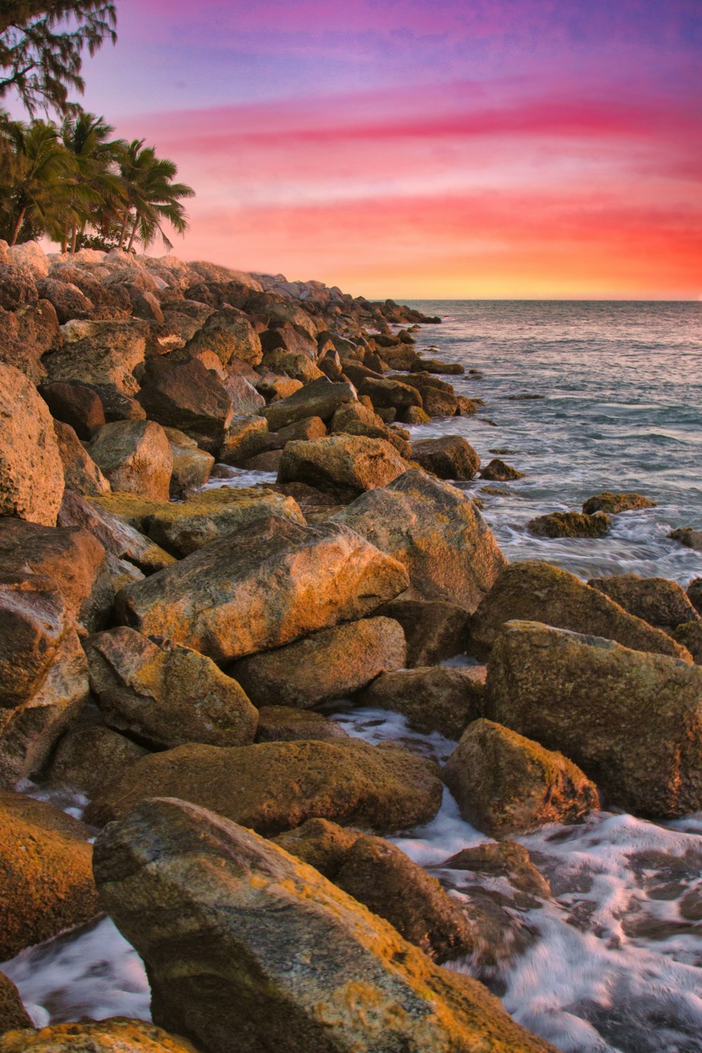 Rocas marrones y grises junto al cuerpo de agua durante el día