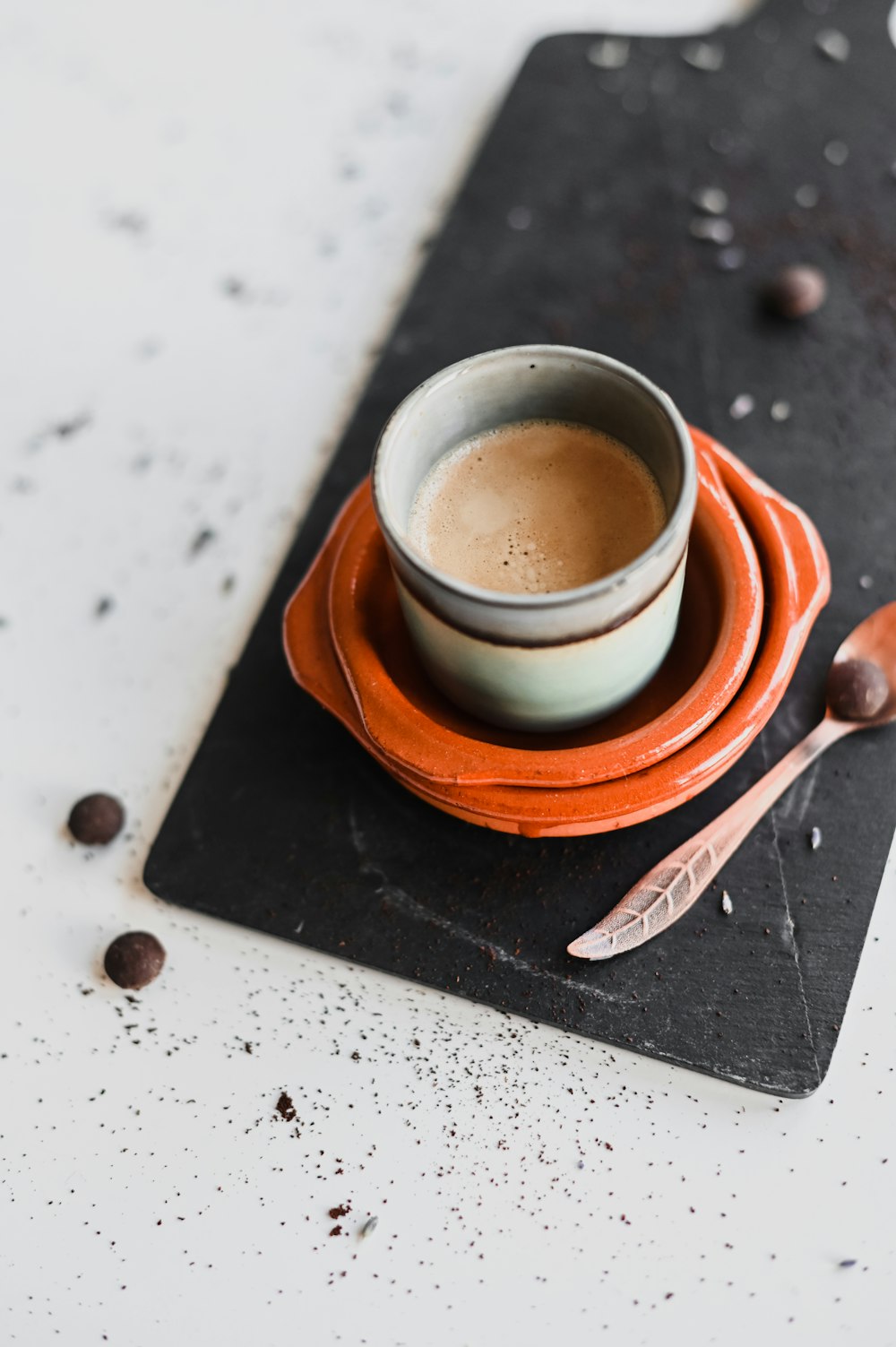 Tasse en céramique blanche sur soucoupe brune