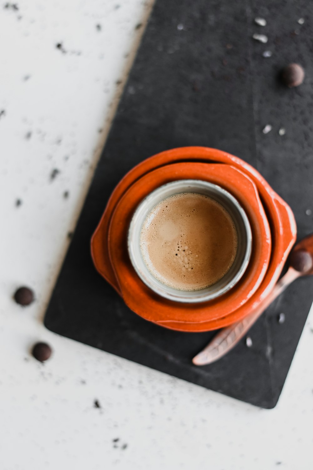 Taza de cerámica marrón sobre mesa blanca