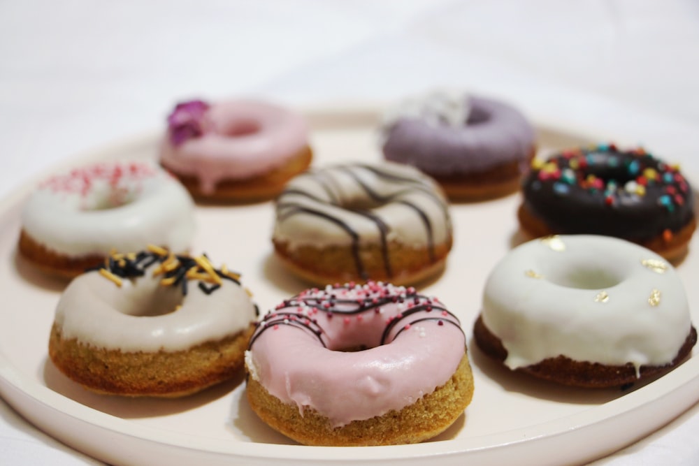 chocolate doughnut with white icing on white ceramic plate