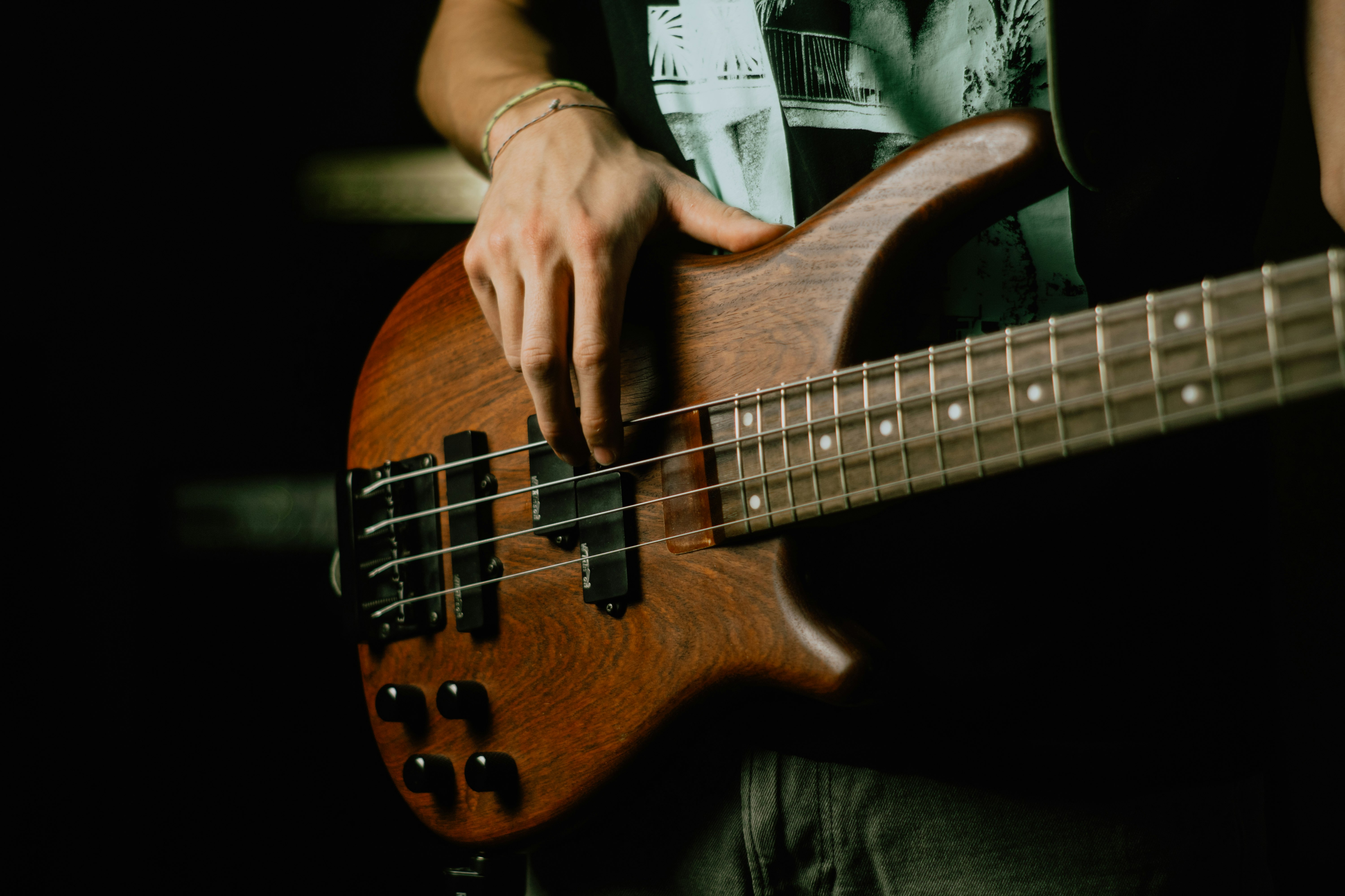 person holding brown and black electric guitar