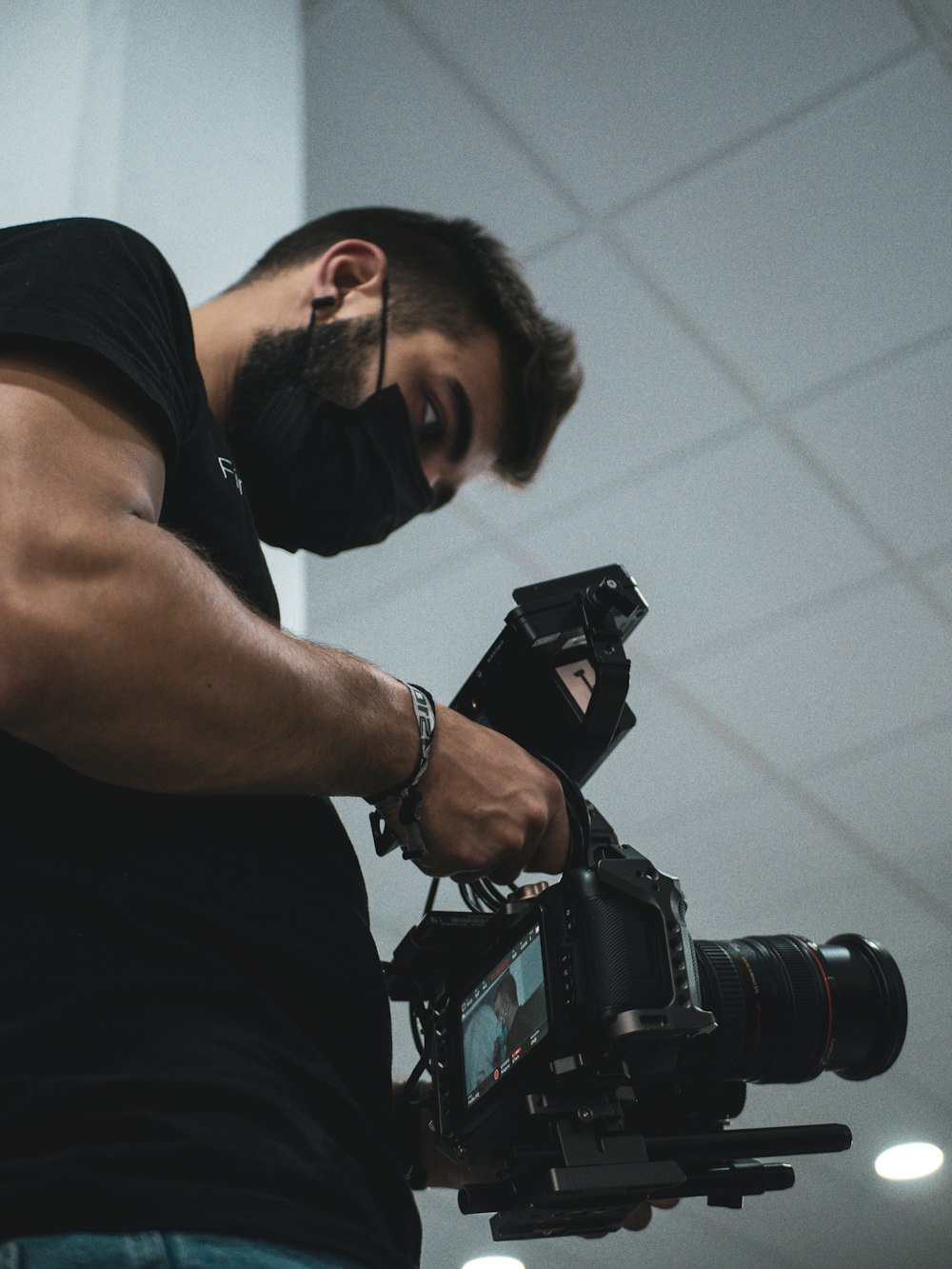 man in black t-shirt holding black dslr camera