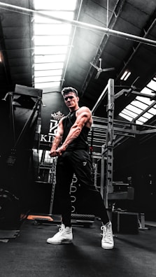 Gym-goer wearing strongbuild apparel mid-squat, muscles flexed under gym lights.