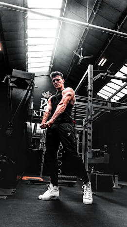 Close-up of a fitness enthusiast stretching muscles after a workout session in a bright gym.