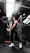 Athletic person wearing gymnx black compression wear, mid-workout in a sleek gym setting.