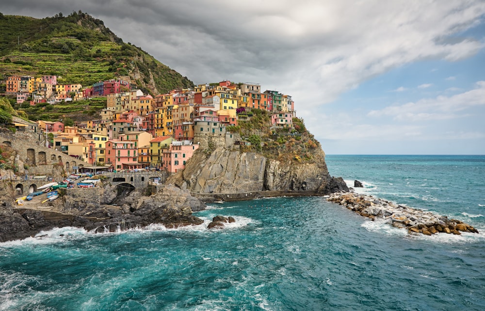 houses on cliff beside sea under blue sky during daytime