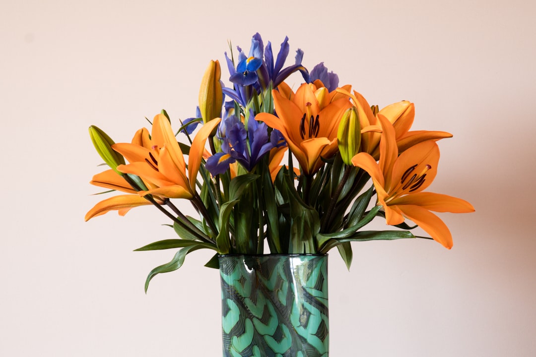 yellow and blue flowers in blue glass vase