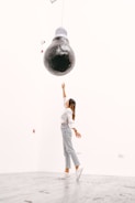 woman in white sleeveless dress standing on globe